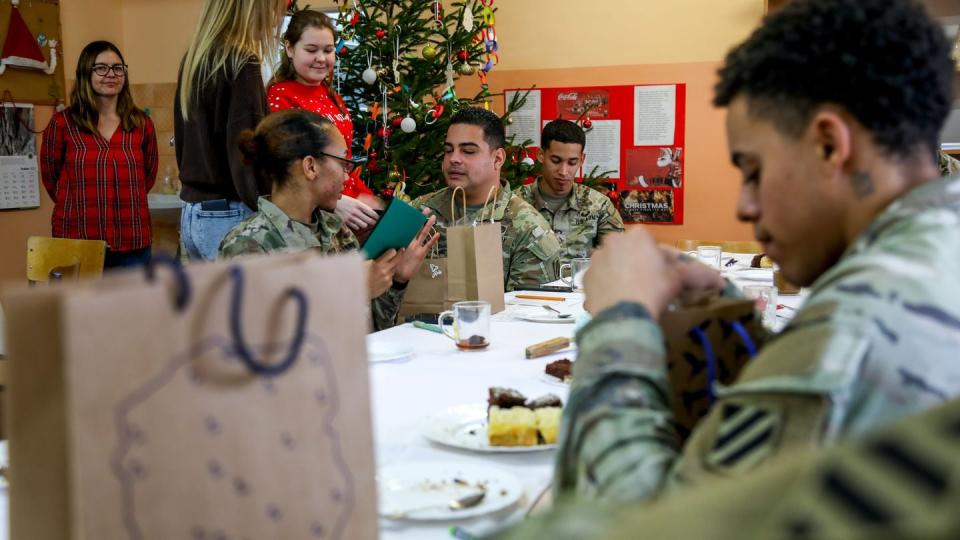 Soldiers assigned to the 3rd Division Sustainment Brigade, 3rd Infantry Division currently deployed to Poland, receive gifts made by students at a school holiday party at the Powidz primary school on Dec. 12. (Sgt. 1st Class Jason Hull/Army)