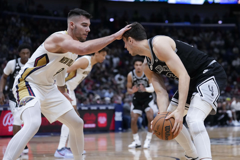 New Orleans Pelicans center Willy Hernangomez guards against San Antonio Spurs forward Zach Collins in the second half of an NBA basketball game in New Orleans, Thursday, Dec. 22, 2022. The Pelicans won 126-117. (AP Photo/Gerald Herbert)