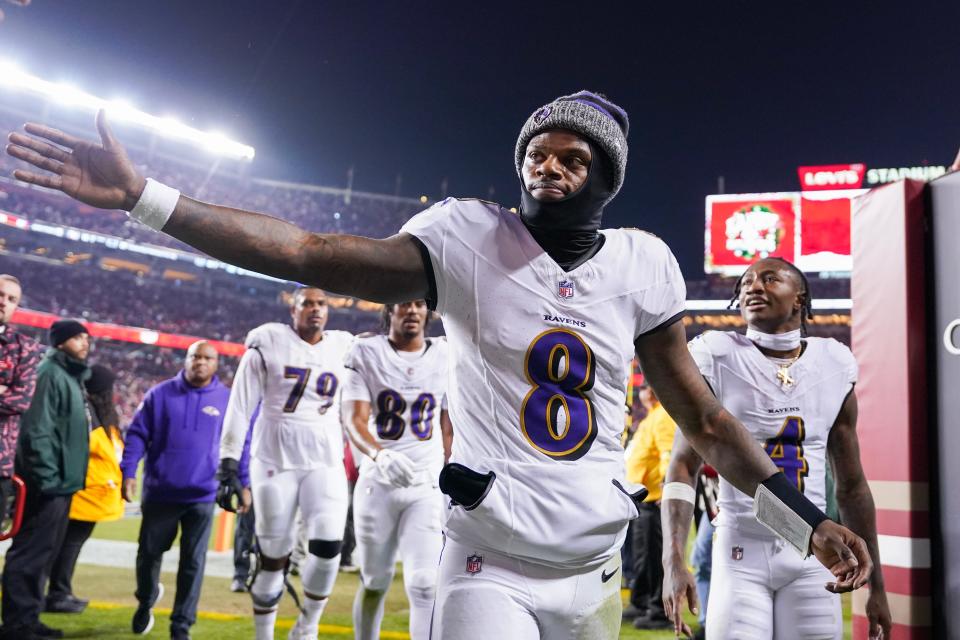 Lamar Jackson #8 of the Baltimore Ravens high fives a fan while heading into the locker room after the first half against the San Francisco 49ers at Levi's Stadium on December 25, 2023 in Santa Clara, California.