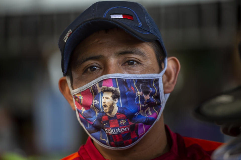 Un hombre usa una mascarilla con la imagen de Lionel Messi, astro argentino del Barcelona, en el mercado La Terminal de Ciudad de Guatemala, el jueves 21 de mayo de 2020 (AP Foto/Moisés Castillo)