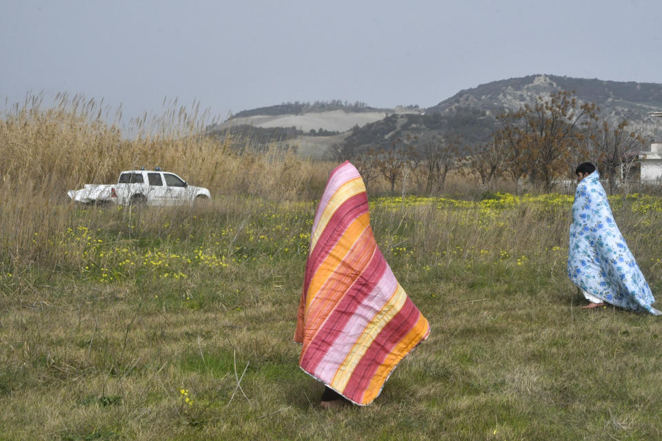 Rescued migrants covered in blankets, stand at a beach near Cutro, southern Italy, after their boat broke apart in rough seas, on Sunday, Feb. 26, 2023. Rescue officials say an undetermined number of migrants have died and dozens have been rescued after their boat broke apart off southern Italy. (AP Photo/Giuseppe Pipita)