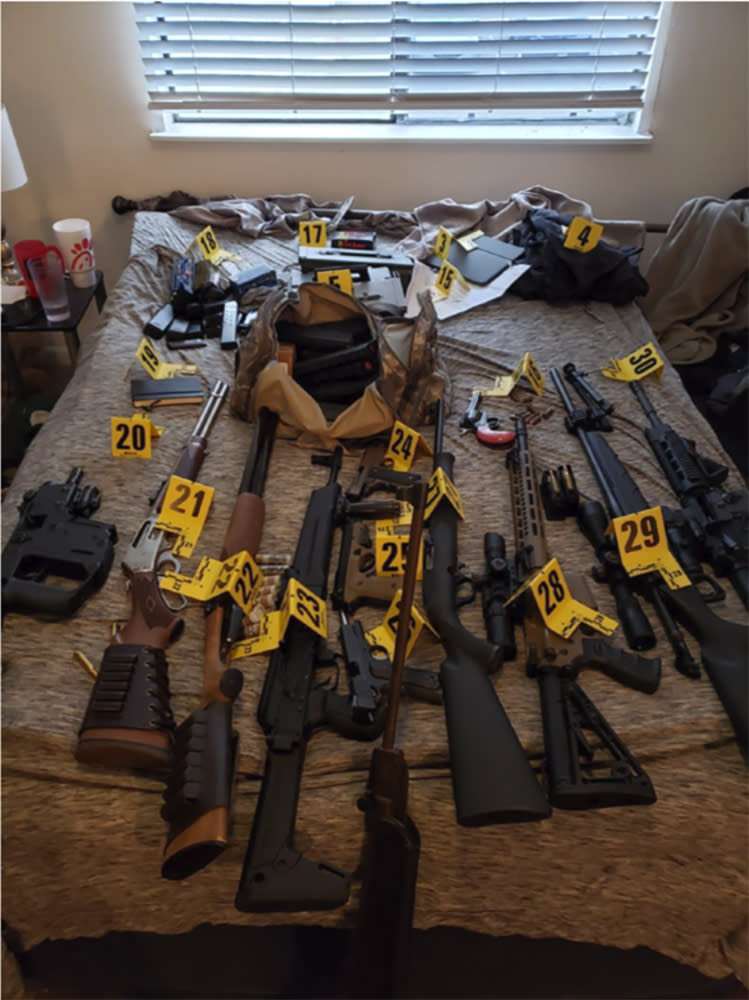 This photo provided by U.S. Attorney for the Middle District of Tennessee shows an evidence photo showing assault rifles that were found during a search of Eric Munchel's home. In a court filing ahead of a Friday, Jan. 22, 2021 detention hearing, prosecutors describe a search of Munchel's home that turned up assault rifles, a sniper rifle with a tripod, shotguns, pistols, hundreds of rounds of ammunition, and a drum-style magazine. Prosecutors also said they have reason to believe Munchel may have had weapons with him in Washington D.C. that he stashed outside the Capitol before entering. (U.S. Attorney for the Middle District of Tennessee via AP)