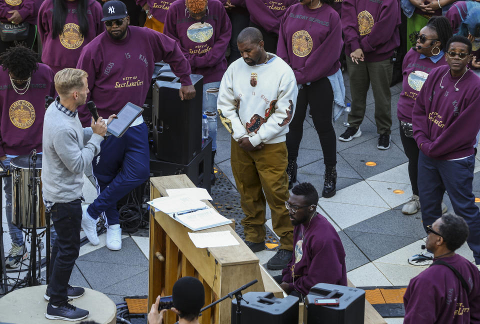 Kanye West, centro, durante una oración en su "Sunday Service" en The Gateway en Salt Lake City el sábado 5 de octubre de 2019. Miles de personas llegaron para ver a West en su misa-concierto. (Colter Peterson/The Deseret News via AP)