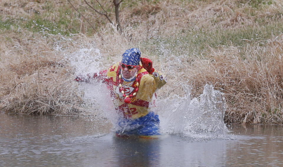 Kansas City Chiefs fan Ty Rowton, known as XFactor, takes a Plunge for Landon in a farm pond near Bonner Springs, Kan., Friday, April 4, 2014. A 5-month-old boy's battle with cancer has inspired hundreds to jump into cold bodies of water, from a local golf course pond to the Gulf of Mexico and even the Potomac River in Washington, D.C. (AP Photo/Orlin Wagner)