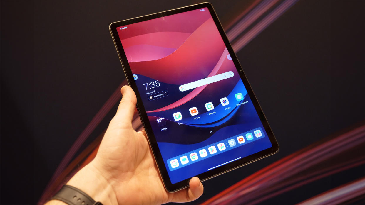  Lenovo Tab M11 tablet being held in front of a Lenovo backdrop at CES 2024. 