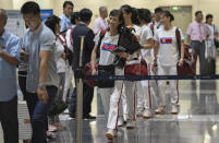 A North Korean woman wearing a T-shirt with the North Korean flag reacts after checking in for a flight to Astana at the Capital Airport in Beijing, Friday, Aug. 18, 2023. A team of North Korean Taekwondo athletes are reportedly travelling via China to Astana, capital of Kazakhstan, to compete in a Taekwondo competition. (AP Photo/Ng Han Guan)