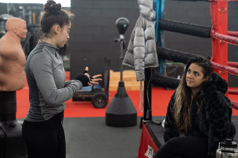 Nov 25, 2023; East Hanover, NJ, USA; Elise Soto, 18, wraps her hands as her mother Veronica Soto looks on at the Fitness Superstore LLC basement gym. Elise Soto is preparing to compete in boxing at the Olympic Trials.