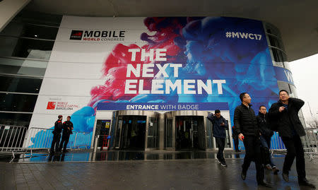 People walk past the main entrance of the Mobile World Congress in Barcelona, Spain February 24, 2017. REUTERS/Albert Gea