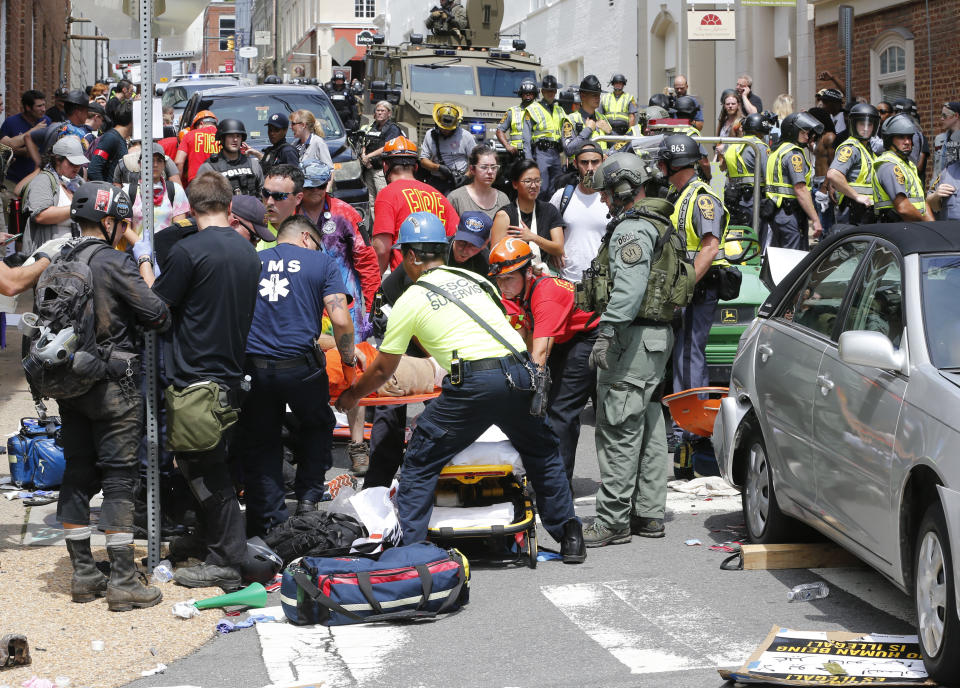 <p>Rescue personnel help injured people after a car ran into a large group of protesters after an white nationalist rally in Charlottesville, Va., Saturday, Aug. 12, 2017. (Photo: Steve Helber/AP) </p>