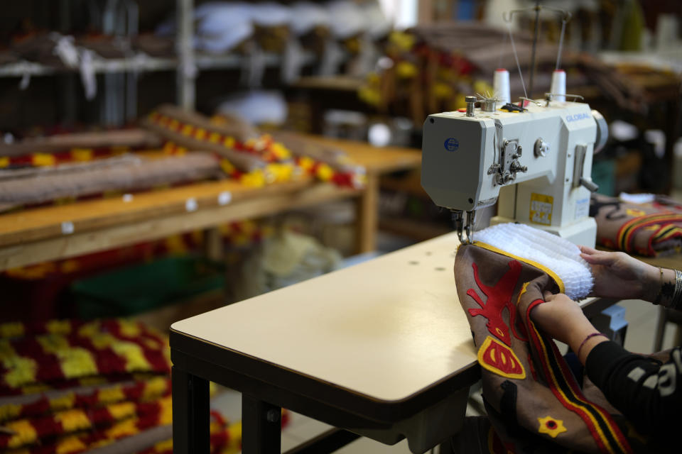 A woman works on a Gilles of Binche costume at a sewing machine in the Kersten family costume workshop in Binche, Belgium, Wednesday, Feb. 1, 2023. After a COVID-imposed hiatus, artisans are putting finishing touches on elaborate costumes and floats for the renowned Carnival in the Belgian town of Binche, a tradition that brings together young and old and is a welcome moment of celebration after a rough few years. (AP Photo/Virginia Mayo)