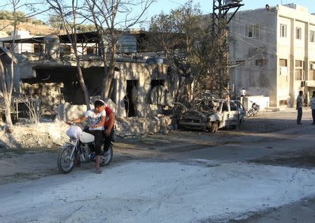 People inspect the damage as they stand near a Save the Children sponsored maternity hospital after an airstrike in the rebel-controlled town of Kafer Takhareem in Idlib province, Syria July 29, 2016. REUTERS/Ammar Abdullah