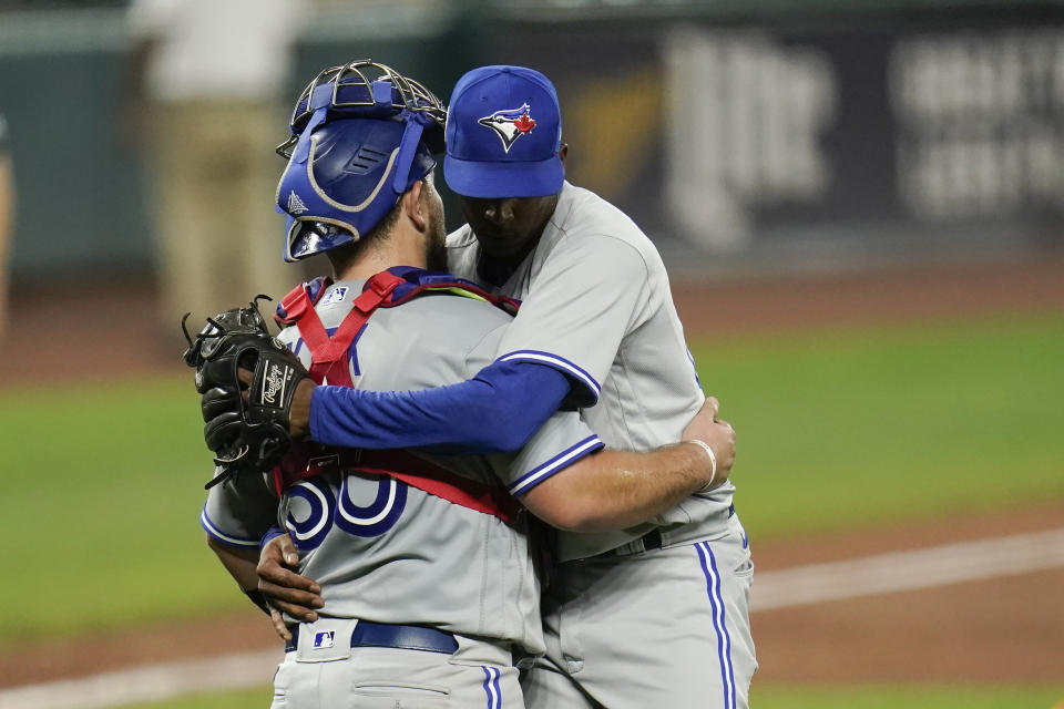Toronto Blue Jays catcher Alejandro Kirk, left, and relief pitcher Anthony Castro embrace after defeating the Baltimore Orioles during the second game of a baseball doubleheader, Saturday, Sept. 11, 2021, in Baltimore. The Blue Jays won 11-2. (AP Photo/Julio Cortez)