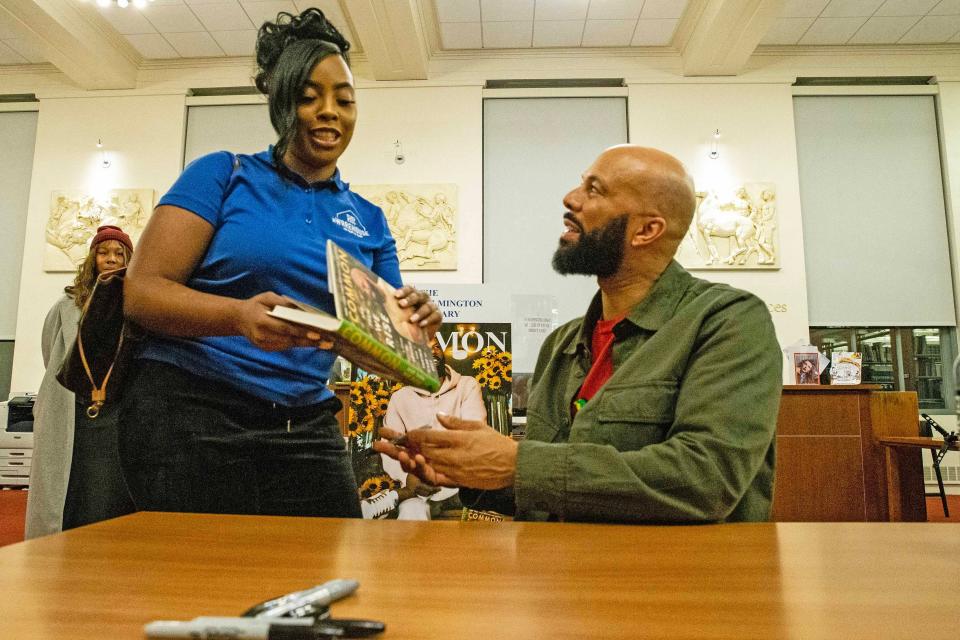 The rapper Common (right) split with comedian Tiffany Haddish in 2021. Common prepares to sign his book for a fan during a book talk and signing event for 'And Then We Rise: A Guide to Loving and Taking Care of Self' at Wilmington Public Library on Friday, Jan 26, 2024.