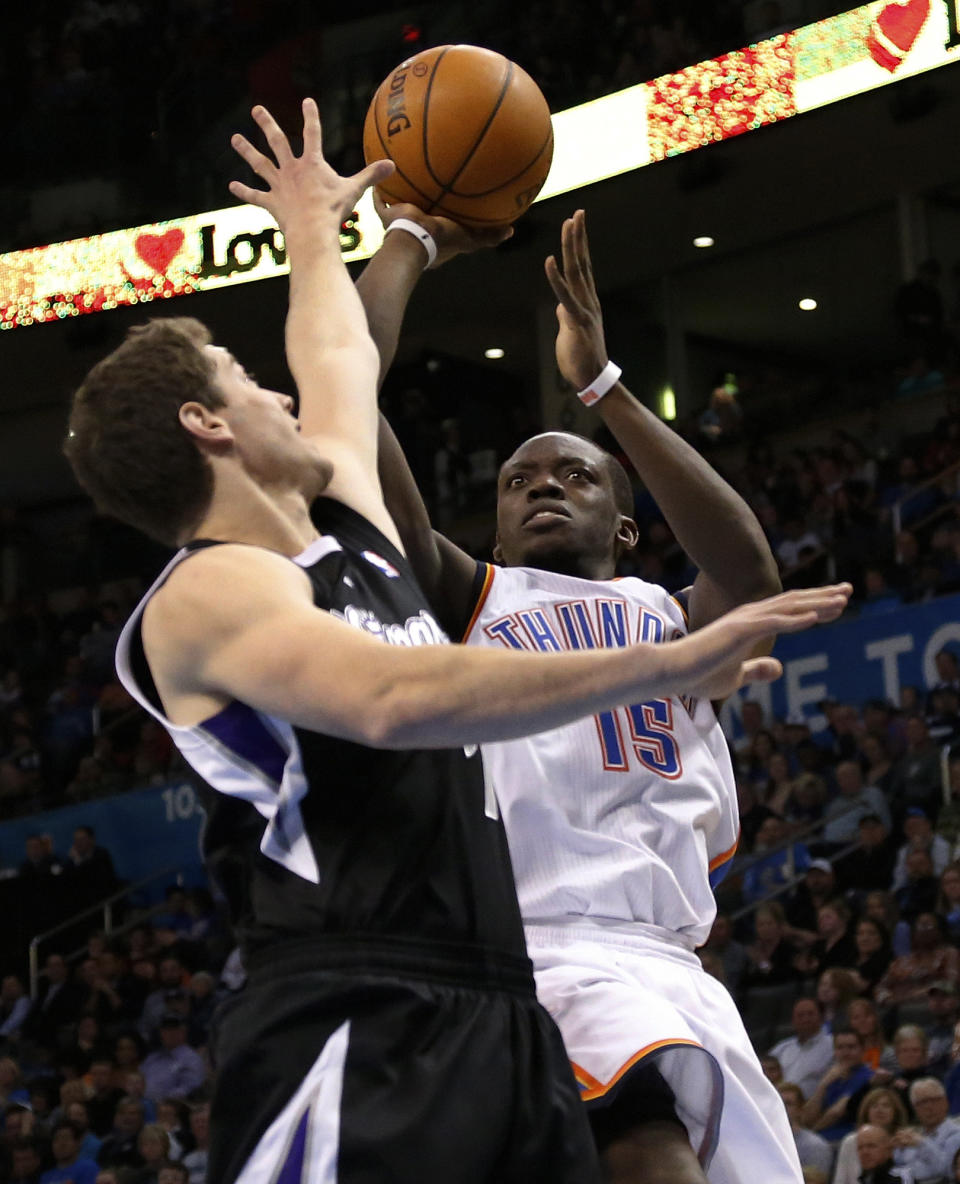 Oklahoma City Thunder guard Reggie Jackson (15) shoots as Sacramento Kings guard Jimmer Fredette (7) defends in the fourth quarter of an NBA basketball game in Oklahoma City, Sunday, Jan. 19, 2014. Oklahoma City won 108-93. (AP Photo/Sue Ogrocki)