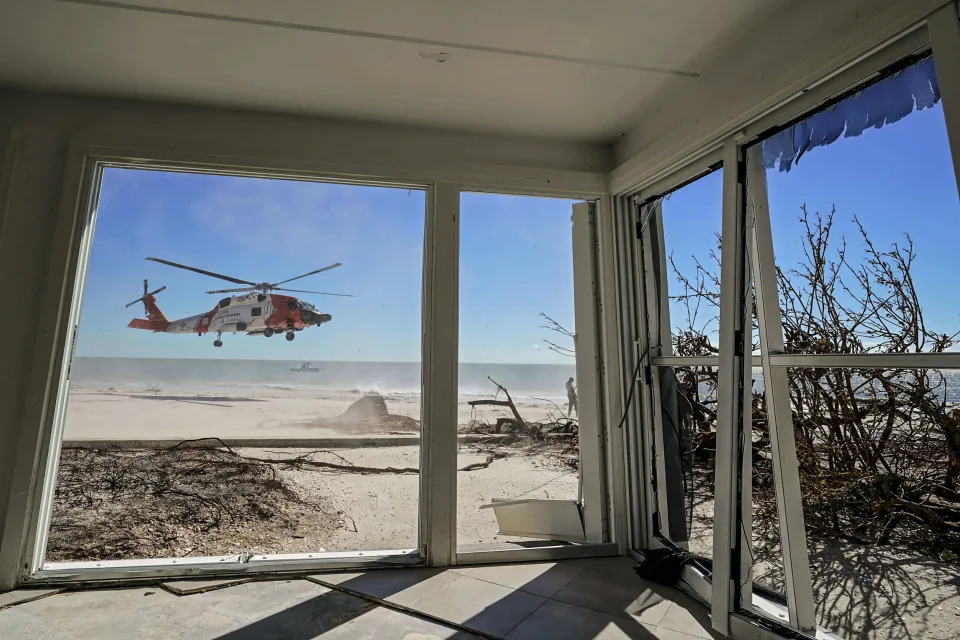 Image: A U.S. Coast Guard helicopter takes off, seen from inside a home damaged by Hurricane Ian on Sanibel Island, Fla., on Sept. 30, 2022. (Steve Helber / AP filw)