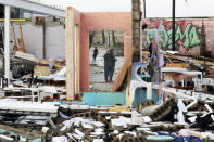 People are reflected in a mirror of a building destroyed by storms Tuesday, March 3, 2020, in Nashville, Tenn. Tornadoes ripped across Tennessee early Tuesday, shredding buildings and killing multiple people. (AP Photo/Mark Humphrey)