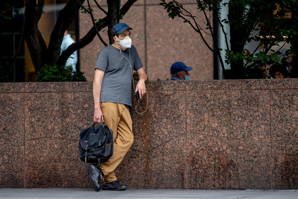 A man wearing an N-95 style mask rests near Times Square as tourism and entertainment start returning to the city on August 09, 2021 in New York City. (Roy Rochlin / Getty Images)