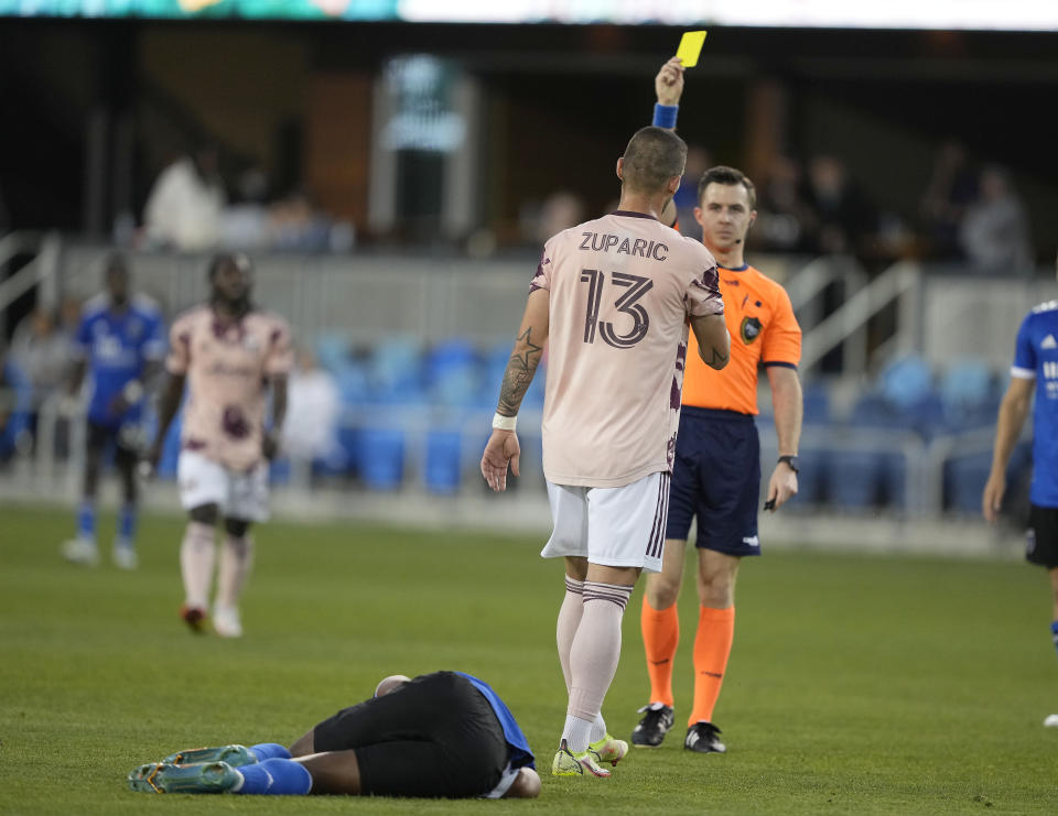 Portland Timbers defender Dario Župaric (13) receives a yellow card from referee Lukas Sepala after fouling San Jose Earthquakes forward Jeremy Ebobisse, on the ground, during the first half of an MLS soccer match in San Jose, Calif., Wednesday, May 18, 2022. (AP Photo/Tony Avelar)