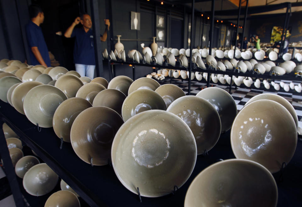 Guards stand near 10th century Chinese Yue Mise imperial wares from the Five Dynasties (907-960 AD) on display at a showroom in Pamulang district, Tangerang, Indonesia's Banten province May 4, 2010. The items were found inside a 1,000-year-old shipwreck discovered by Indonesian fishermen and excavated by PT Paradigma Putra Sejahtera with Cosmix Underwater Research Ltd in the northern waters of Cirebon, West Java province, and are set to go on auction on May 5, 2010 with a minimum price of $80 million, said Fadel Muhammad, Indonesia's Fishery and Maritime Minister, on Tuesday. The collection includes 271,000 pieces such as rubies, pearls, gold jewellery, rock crystal, Iranian glassware and Chinese imperial porcelain, all of which can be dated to around 976 A.D. REUTERS/Beawiharta