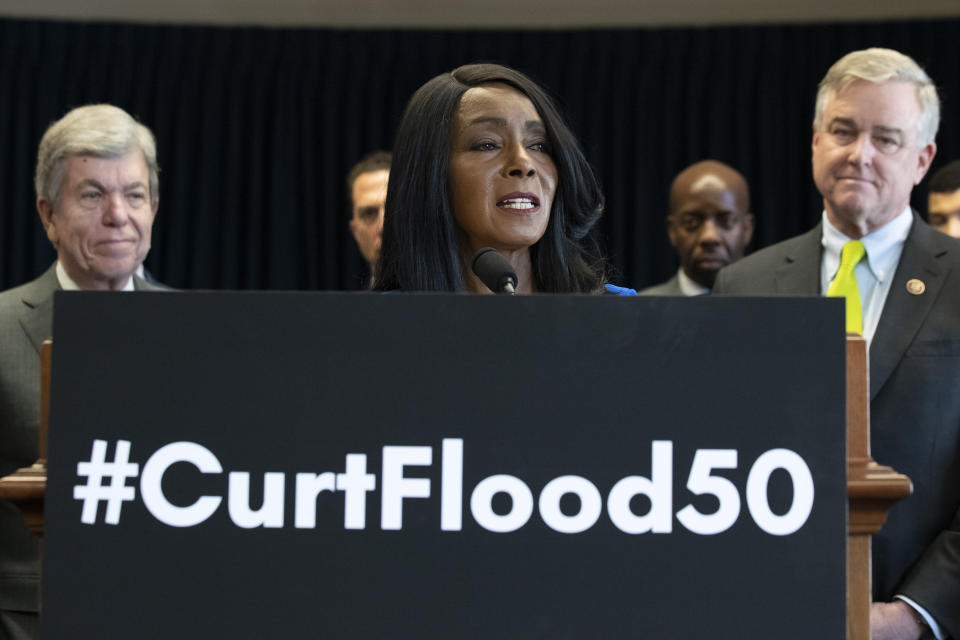Sen. Roy Blunt, R-Mo., left, and Rep. David Trone, D-Md., right, stand as and Judy Pace Flood, speaks during a news conference to call for the late Curt Flood to be inducted into the Baseball Hall of Fame, on Capitol Hill, Thursday, Feb. 27, 2020 in Washington. (AP Photo/Alex Brandon)