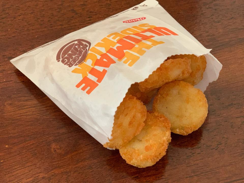 Burger King hash browns in original bag on a wooden table