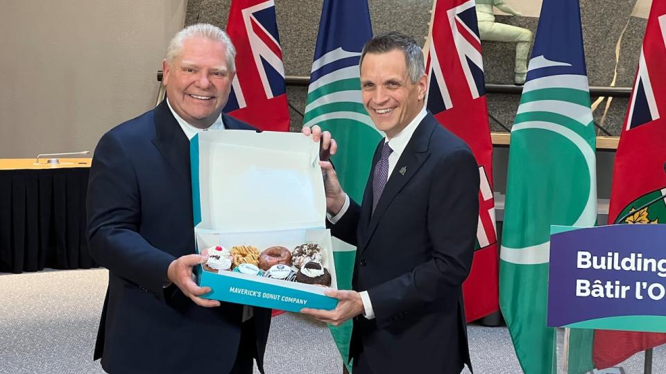 Premier Doug Ford receives a dozen doughnuts from Mayor Mark Sutcliffe in Ottawa on April 5. The doughnuts were produced by Maverick's Donut Company.