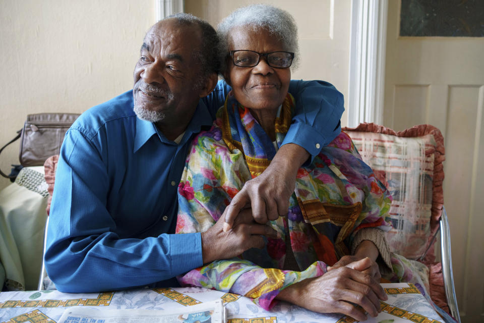 Sylius and Bridgette Toussaint pose for a photo at their home in Preston, England, Tuesday, April 25, 2023. The pair as children in Dominica remember the coronation of Elizabeth II which took place at Westminster Abbey on 2 June 1953. Sylius Toussaint, now 83, still remembers the coronation song he learned seven decades ago, chuckling as he softly croons out the blessing for "our queen who is crowned today," only occasionally stumbling over a phrase lost to the passage of time. (AP Photo/Jon Super)