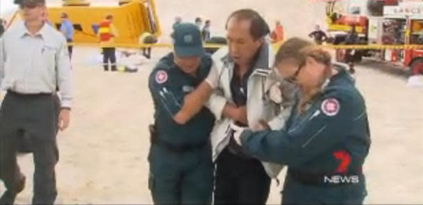 Australian medics escort an injured passenger to an ambulance after the tour bus crash in Lancelin, Western Australia. (Photo: Seven News)