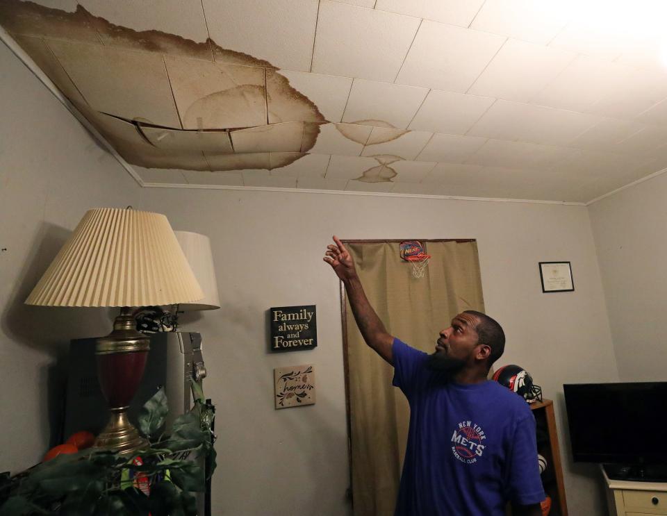Stepfon Brooks shows where a leak has stained his dining room ceiling.