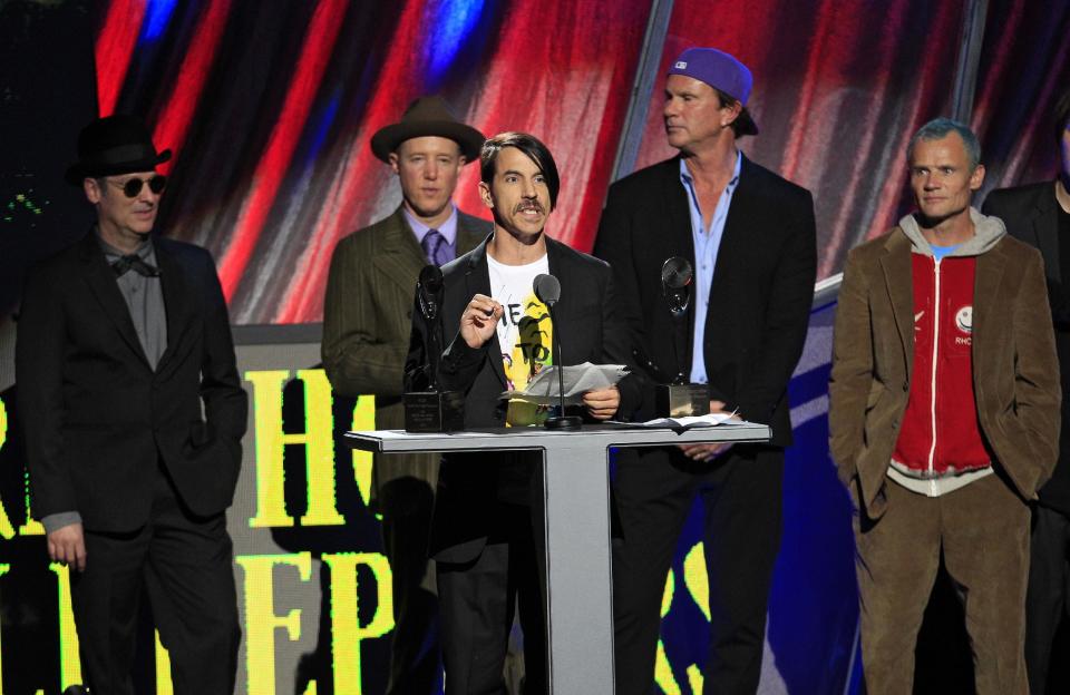 Red Hot Chili Peppers' Anthony Kiedis speaks after induction into the Rock and Roll Hall of Fame Sunday, April 15, 2012, in Cleveland. Former members Cliff Martinez, far left, and Jack Irons, join Chad Smith, second from right, and Mike "Flea" Balazary, right, onstage. (AP Photo/Tony Dejak)