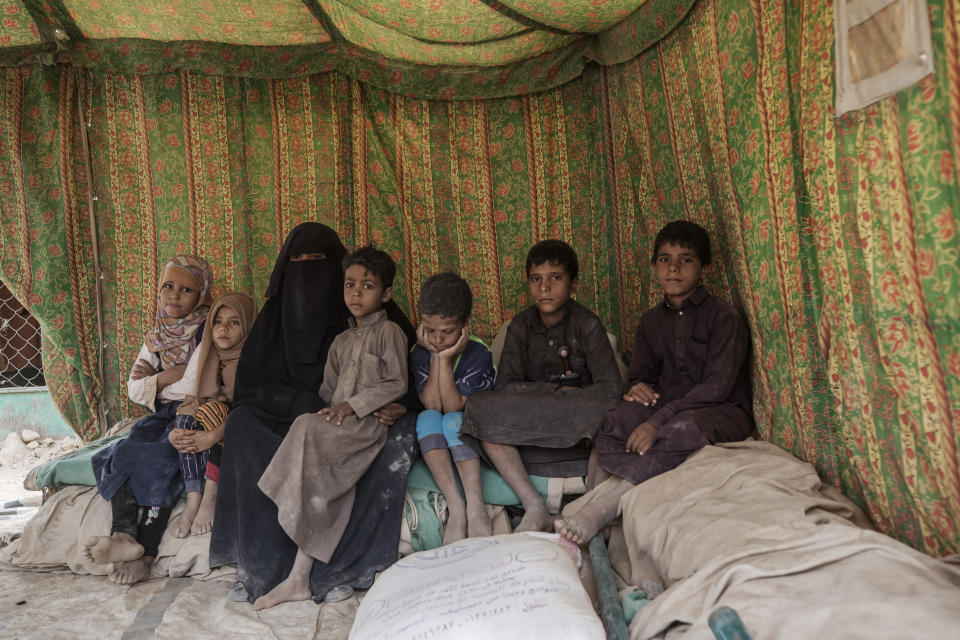 FILE - Faiza Abdo Mohammed Kassem, poses for a photograph with her children near their shelter in the al-Suwayda camp for displaced persons on the outskirts of Marib, Yemen, June 21, 2021. A stark warning from international charity group Oxfam on Tuesday, Feb. 8, 2022, said a yearlong battle over the strategic Yemeni city of Marib has displaced about 100,000 people and underscored how the fighting has worsened an already dire humanitarian situation. (AP Photo/Nariman El-Mofty, File)