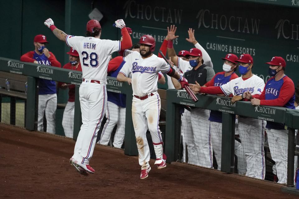 Texas Rangers' Jonah Heim (28) and Isiah Kiner-Falefa celebrate a solo home run by Heim during the sixth inning of the team's baseball game against the Toronto Blue Jays in Arlington, Texas, Tuesday, April 6, 2021. The home run was Heim's first in the majors. (AP Photo/Tony Gutierrez)