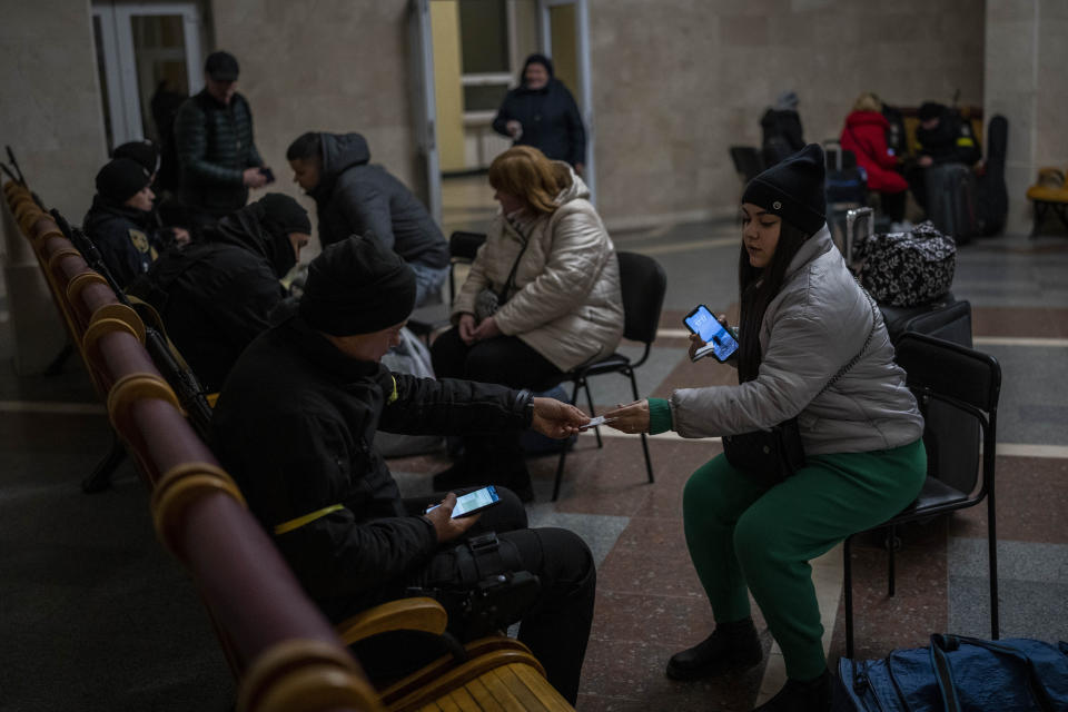 Ukrainian police conduct a security check on passengers before boarding the Kherson-Kyiv train at the Kherson railway station, southern Ukraine, Saturday, Nov. 26, 2022. Fleeing shelling, hundreds of civilians on Saturday streamed out of the southern Ukrainian city whose recapture they had celebrated just weeks earlier. (AP Photo/Bernat Armangue)