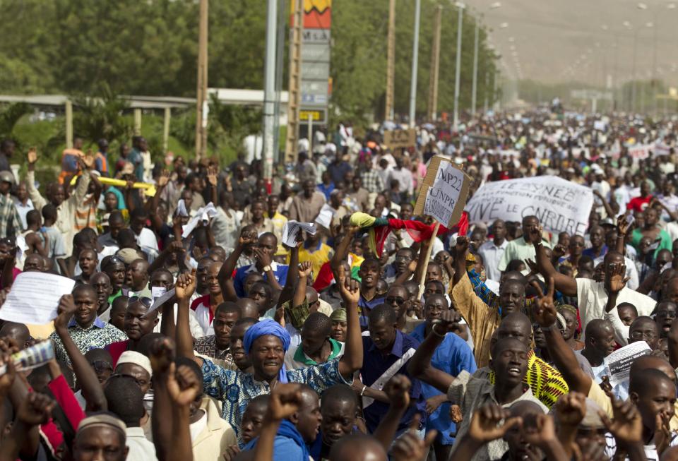 People march along a central street as thousands rallied in a show of support for the recent military coup, in Bamako, Mali Wednesday, March 28, 2012. The body representing nations in western Africa has suspended Mali and has put a peacekeeping force on standby in the most direct threat yet to the junta that seized control of this nation in a coup last week.(AP Photo/Rebecca Blackwell)