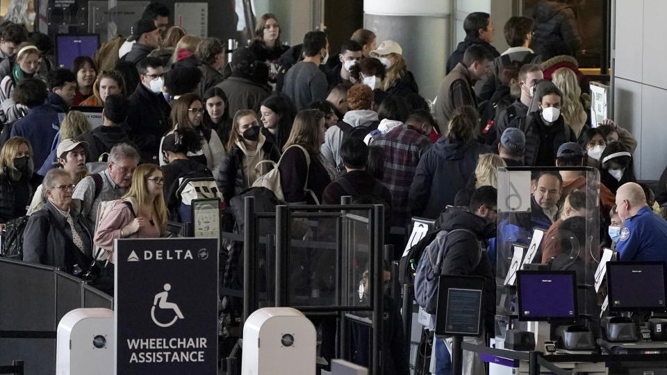 Travelers stand in line at a security checkpoint before boarding their flights the day before Thanksgiving, Wednesday, Nov. 23, 2022, at Logan International Airport in Boston. (AP Photo/Steven Senne)