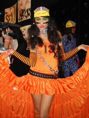 Models dance and pose backstage. This lovely lady is part bike messenger, part crossing guard.