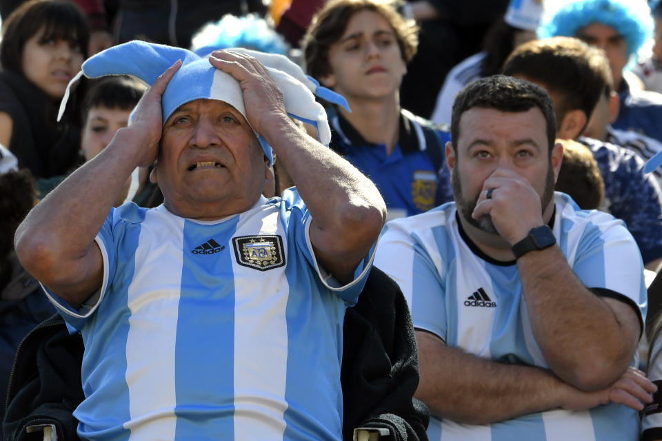 Argentina soccer fans watch the team lose to Saudi Arabia at a World Cup Group C soccer match played in Qatar, on a large screen set up for fans in the Palermo neighborhood of Buenos, Aires, Argentina, early Tuesday, Nov. 22, 2022. (AP Photo/Gustavo Garello)