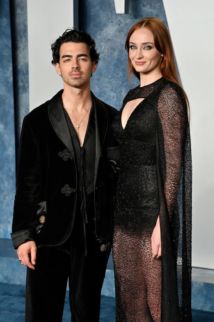 Joe Jonas in a velvet suit with Sophie Turner in a sheer gown at a celebrity event