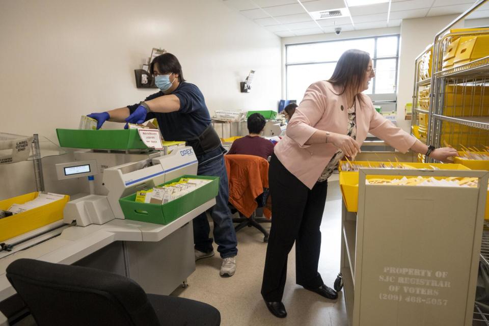 San Joaquin County Registrar of Voters Olivia Hale, right, gathers ballots while the staff continues counting March 11.