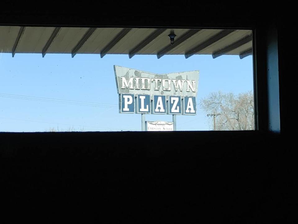 The vintage Midtown Plaza sign is visible through a window at Tee Time, an 18,000-square-foot, 18-hole mini golf course set to open in central Kennewick in April.