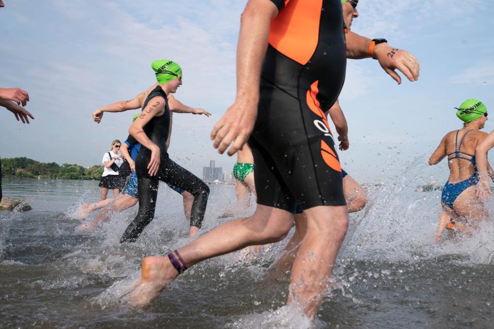 Participants run into the Detroit River during the Swim Across America Motor City Mile open water swim, a charity swim event for cancer research at Belle Isle on Friday, July 8, 2022.