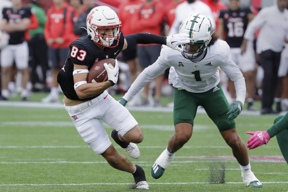 Houston wide receiver Peyton Sawyer (83) makes a gain in front of South Florida safety Matthew Hill (1) during the first half of an NCAA college football game Saturday, Oct. 29, 2022, in Houston. (AP Photo/Michael Wyke)