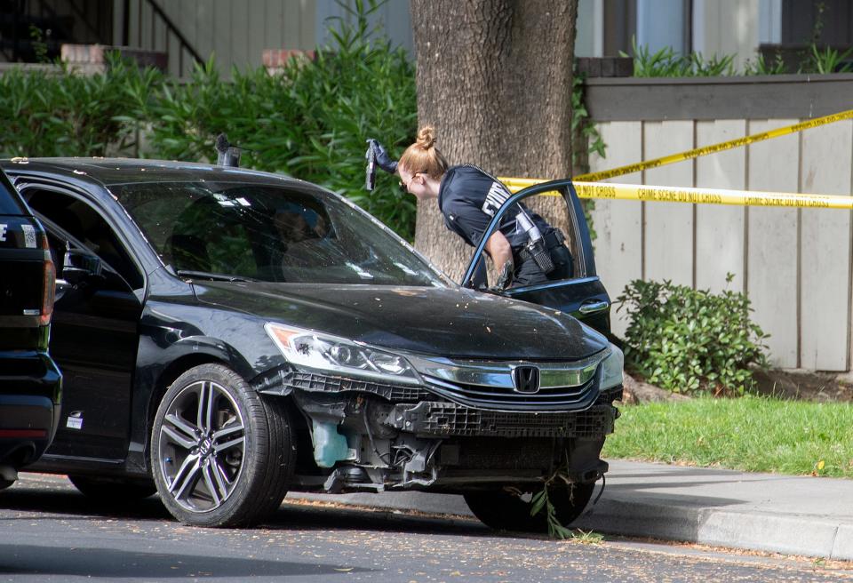 A Stockton Police evidence technician gathers evidence from a Honda Accord after a fatal shooting in Stockton on Tuesday, July 5, 2022.