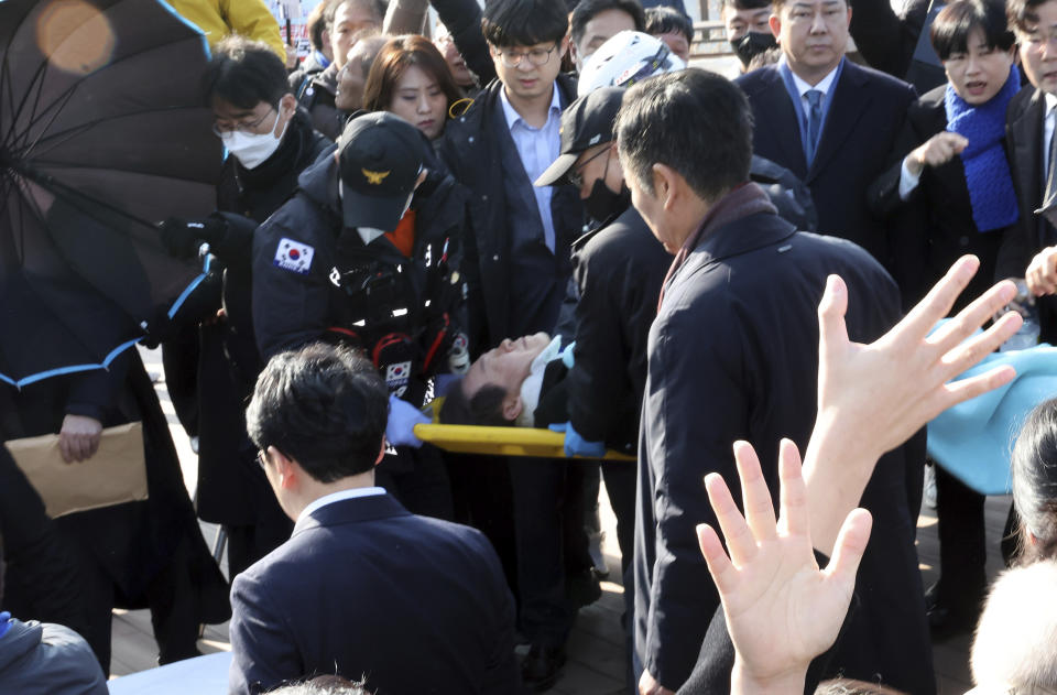 South Korean opposition leader Lee Jae-myung on a stretcher, is carried by rescue team in Busan, South Korea, Tuesday, Jan. 2, 2024. Lee was attacked and injured by an unidentified man during a visit Tuesday to the southeastern city of Busan, emergency officials said. (Ha Kyung-min/Newsis via AP)