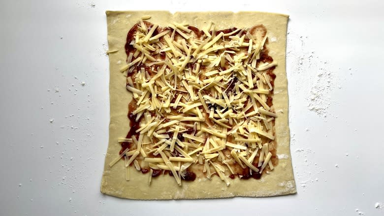 shredded cheese on top of puff pastry sheet