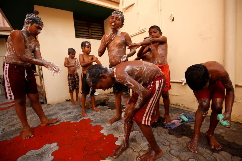 Boys staying in the care home set up by Karibeeran Paramesvaran and his wife Choodamani after they lost three children in the 2004 tsunami, bathe inside at the home in Nagapattinam district in the southern state of Tamil Nadu, India