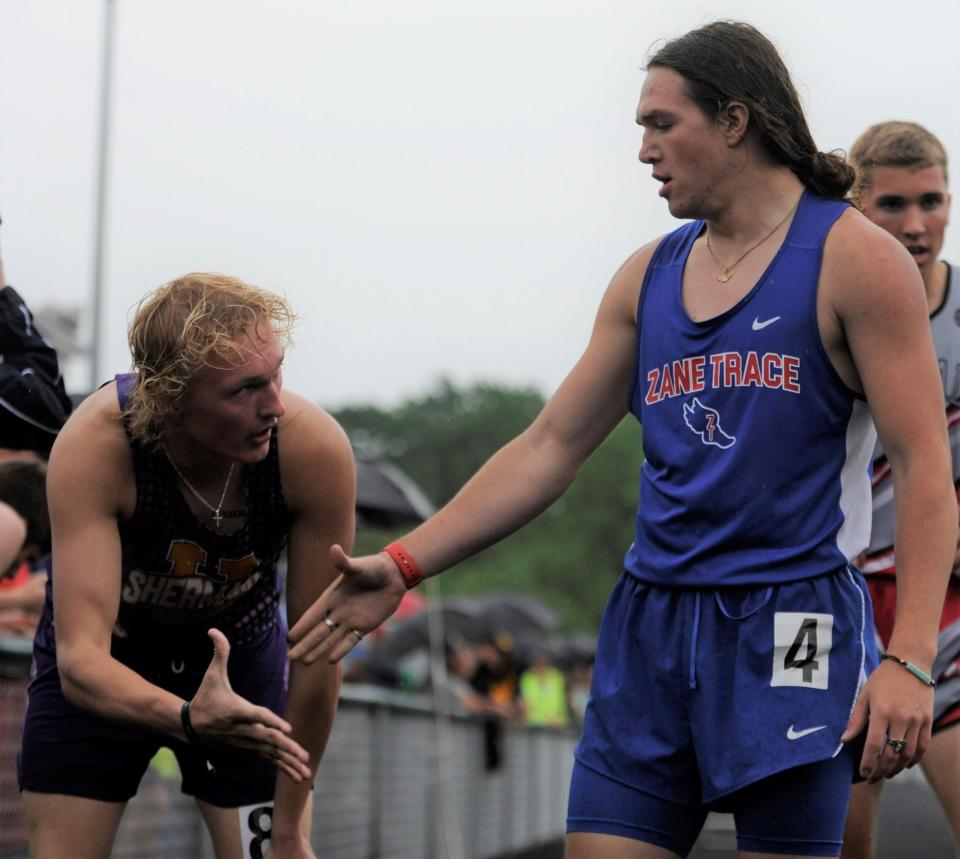 Zane Trace's Charley Clyne (right) shakes hands with Unioto's Kyan Clark (left) after the boys 400m dash in the Scioto Valley Conference track and field championships at Huntington High School on May 12, 2023.