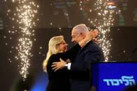 FILE PHOTO: Israeli Prime Minister Benjamin Netanyahu and his wife Sara react as they stand on stage following the announcement of exit polls in Israel's parliamentary election at the party headquarters in Tel Aviv, Israel