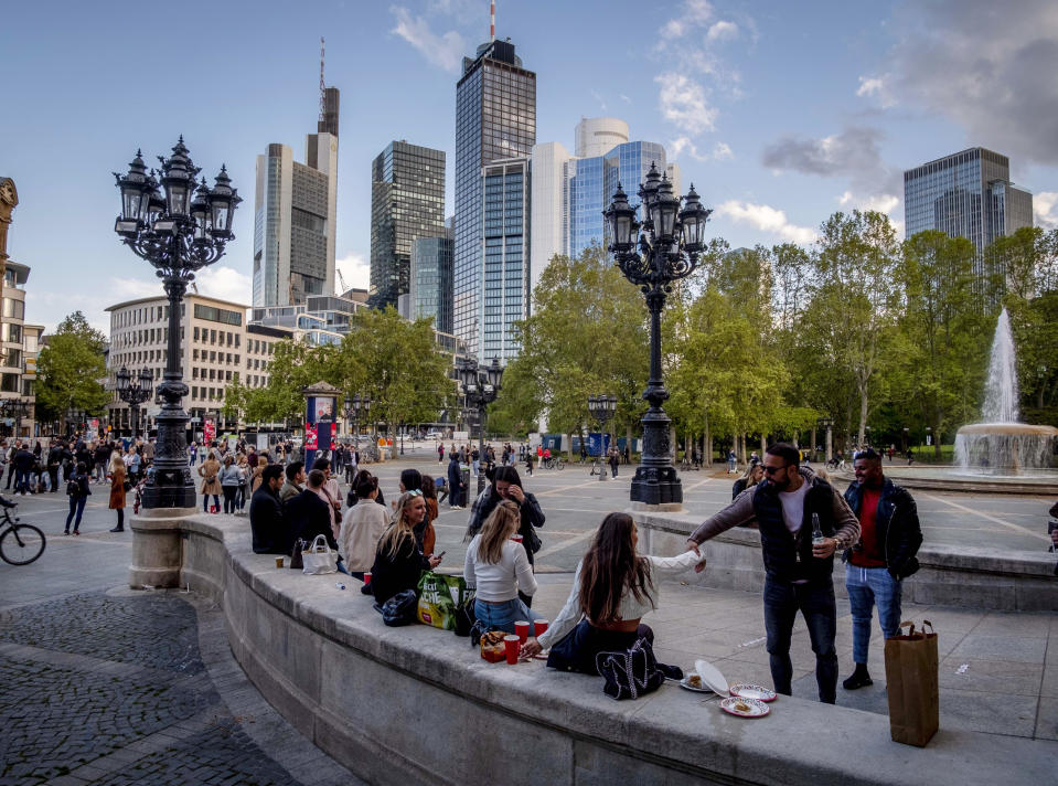 People celebrate the birthday of a young woman in front of the Old Opera with drinks and food in Frankfurt, Germany, Friday, May 21, 2021. All people gathering on the square left when the police started checking if they stick to the corona restrictions. (AP Photo/Michael Probst)