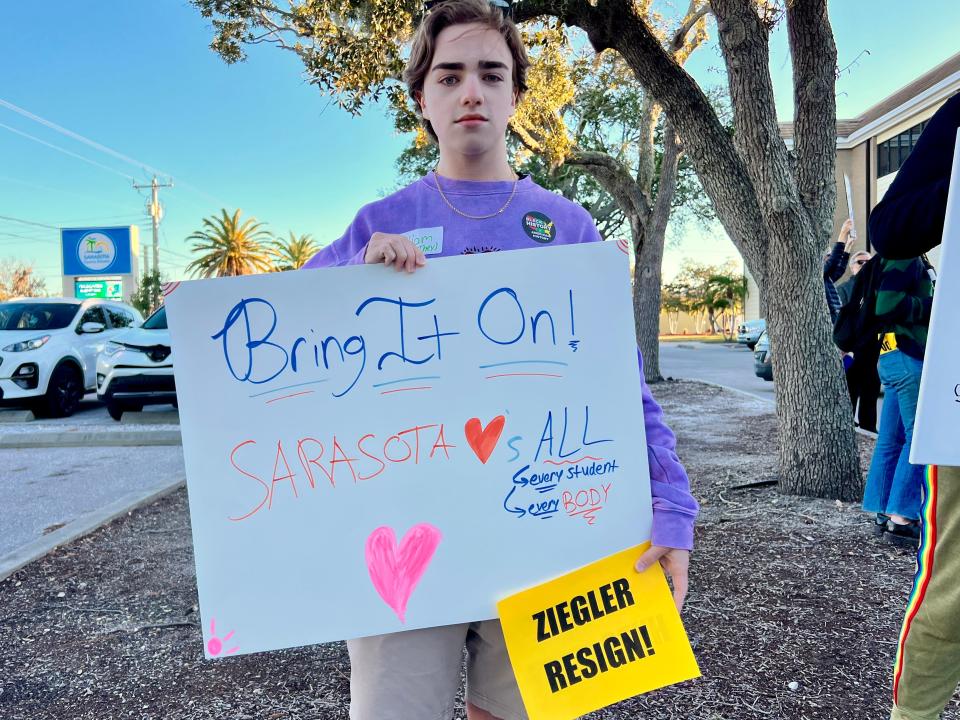 William Harless, a 20-year-old University of Miami student and Venice High alumnus, poses with his sign out front of the Sarasota School Board chambers on Tuesday, February 6, 2024.